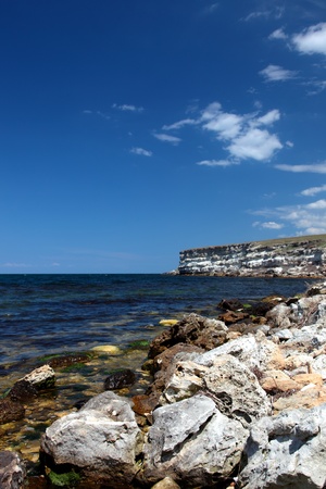 Stone rock on seacoast and blue seaの写真素材