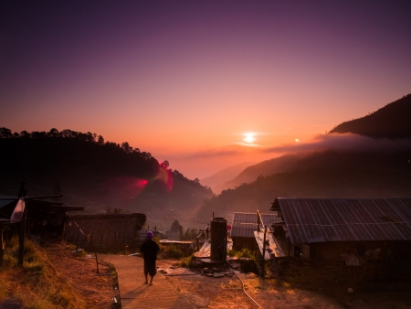 Beautiful mountain and sunrise scene at hill tribe village with a walking manの写真素材