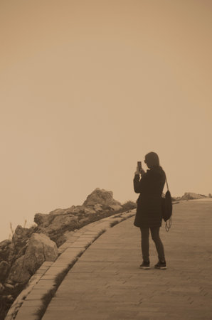woman taking photo with mobile phone at seaside, closeup of photoの写真素材