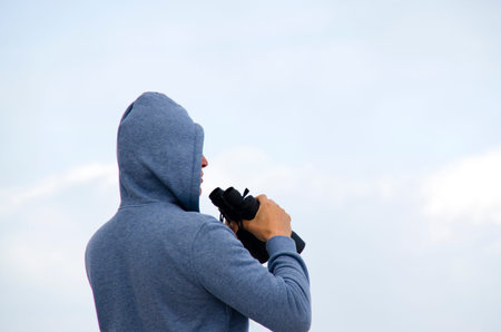 Person taking photos with a digital camera on the blue sky background