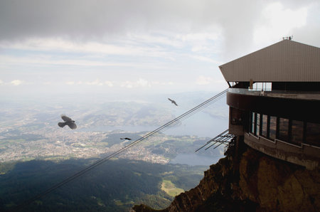 Cable car on top of the mountain with birds flying in the sky
