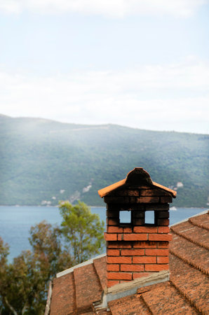 Old brick chimney on the roof of a house in Montenegroの写真素材