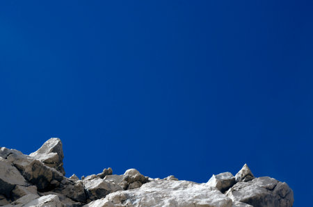 rocky cliff on blue sky background with copy space for your textの写真素材