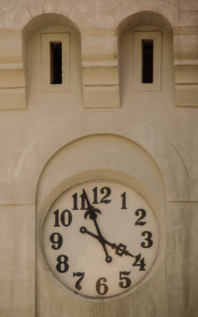 Clock on the wall of an old building. Vintage style photo.