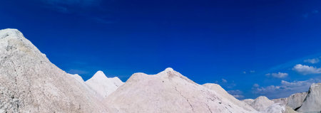 Panoramic view of mountain range against blue sky with white clouds