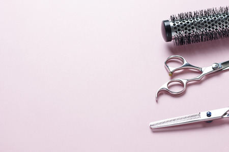 Scissors and comb on a pink background, copy spaceの写真素材