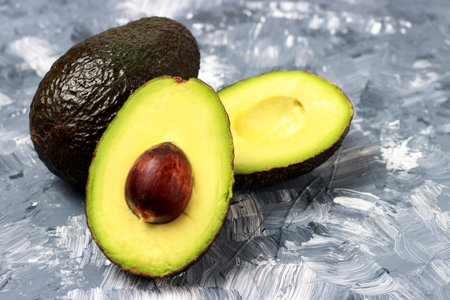 Fresh avocado close-up, top view, white and gray background