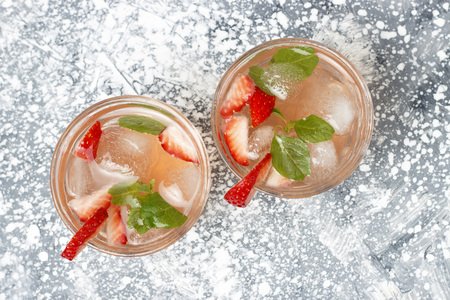 A Cold summer drink with ice and strawberries on a gray background top view, copy spaceの写真素材