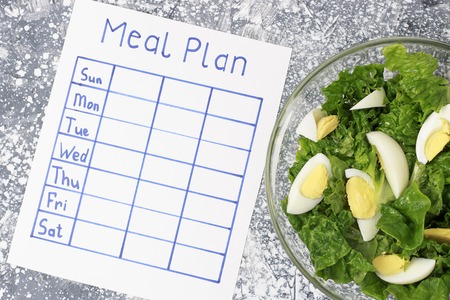 An inscription Meal Plan, schedule on white sheet, concept of weight loss. View from aboveの写真素材