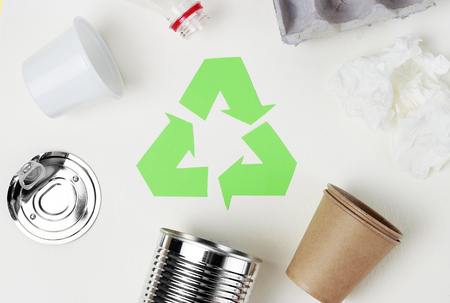 A Green recycle garbage symbol and plastic, iron garbage on white background, top view.の写真素材