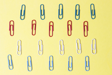 A multicolored paper clips on a yellow background, office conceptの写真素材