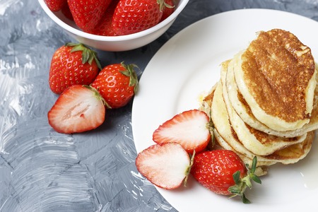 A Pancakes on a plate and strawberries on a gray backgroundの写真素材