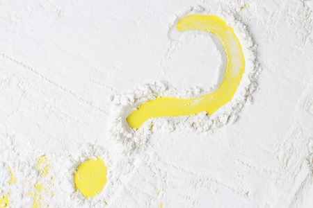 A question mark drawn on a flour, a yellow backgroundの写真素材