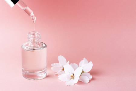 A serum and dropper on a pink background close up, natural cosmetics conceptの写真素材