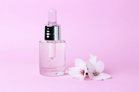 A serum and dropper on a pink background close up, natural cosmetics conceptの写真素材