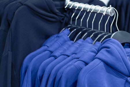 Hoodies on hangers in a clothing store, close up.の写真素材
