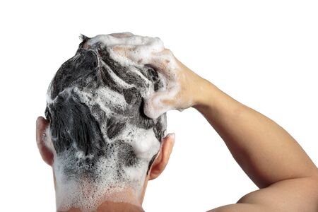 Male hand washes his head with shampoo and foam on a white background, a back viewの写真素材