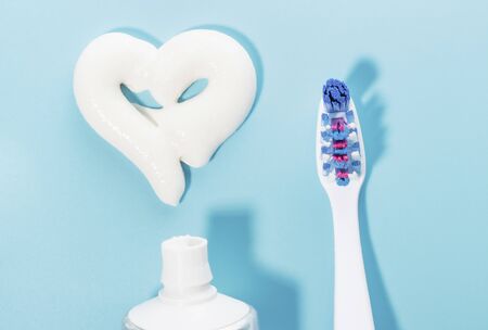 Heart shaped toothpaste and toothbrush on blue background, a dental care concept.の写真素材