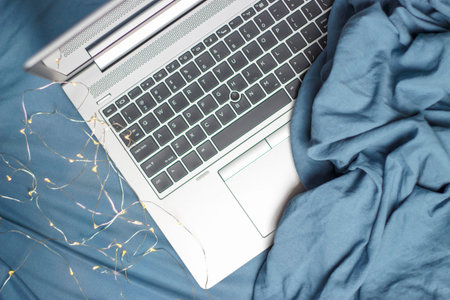 Laptop on a blue bed close up top view