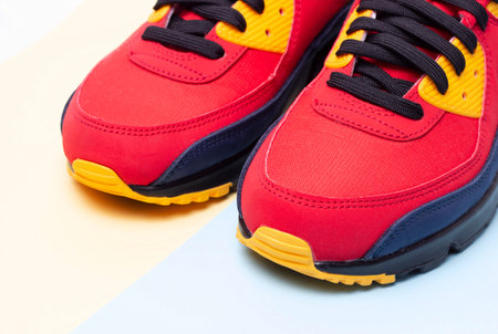 Red sneakers on a blue and yellow background close-up copy space
