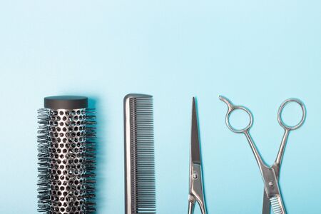 Scissors, comb and brushing, on a blue background, a copy of the spaceの写真素材