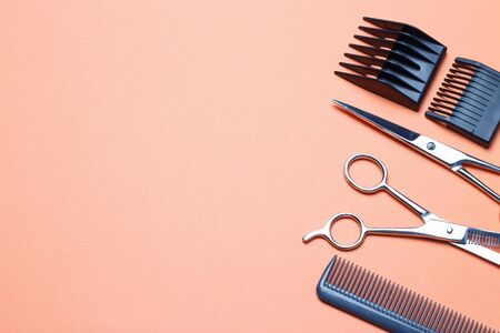 Hairdressing tools, scissors and comb on an orange background, a replica of the spaceの写真素材
