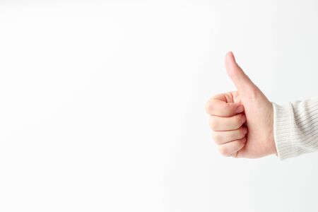 A woman's hand holds a thumbs up on a white background a copy of the spaceの写真素材