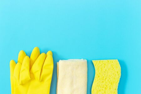 Yellow rubber gloves, rag and sponge on a blue background, a copy of the spaceの写真素材