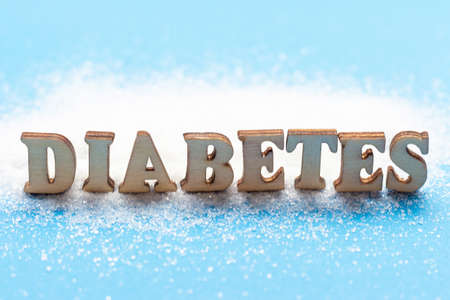 Sugar and the inscription Diabetes from wooden letters front view.の写真素材