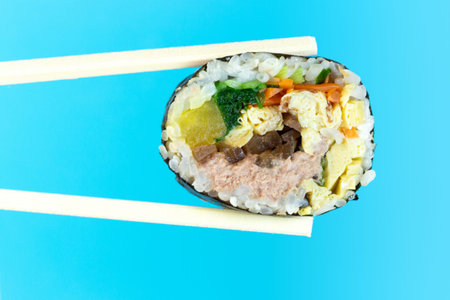 Korean rolls gimbap wooden sticks on a blue background close-up.の写真素材