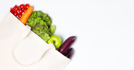Multicolored vegetables and fruits in white linen bag on background.の写真素材