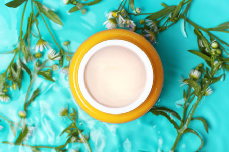 Jar cream and chamomile underwater on a blue backgroundの写真素材
