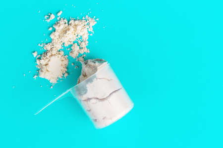Scattered protein in scoop on blue background top view, copy spaceの写真素材