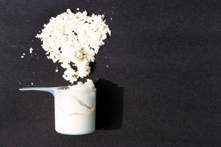 Scattered protein in scoop on black background, copy spaceの写真素材