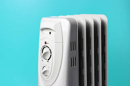 A gray electric heater on a blue background close up.の写真素材