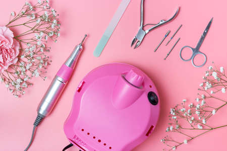 Manicure tools and drill on pink background, top view.の写真素材