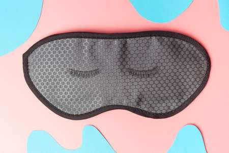 Black false eyelashes on pink and blue background, view from aboveの写真素材