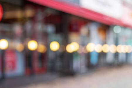 Street cafe and glowing lanterns, blurred urban background.の写真素材