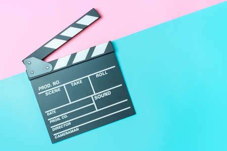 The clapperboard on pink and blue background close-up, top view.の写真素材