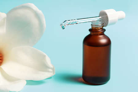 Bottle with serum and pipette on blue background close-up.の写真素材