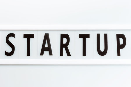 The inscription start-up on white plastic board close-up top view.