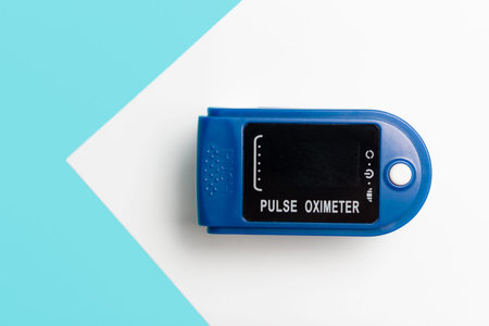Heart rate monitor on blue and white background close up top view.