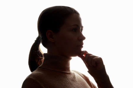 Dark silhouette of girl on white background, concept of anonymity.の写真素材