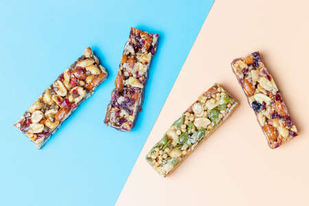 Four protein bars with cereals isolated on brown and blue background.の写真素材