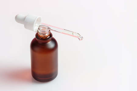 Open bottle with serum and pipette on white background close-up.の写真素材
