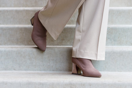 Female legs in trousers and autumn shoes on concrete staircase close-up.の写真素材