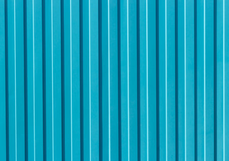 Embossed blue metal fence close-up, texture and background.の写真素材
