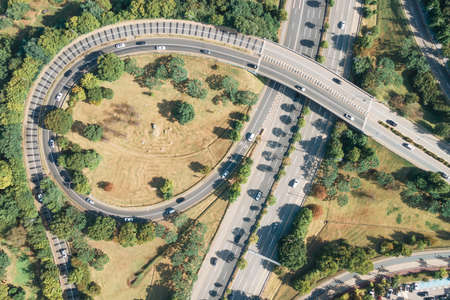 Cars drive along loop shaped road junction aerial view.の写真素材