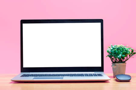 Laptop with white blank screen on wooden table on a pink background.の写真素材