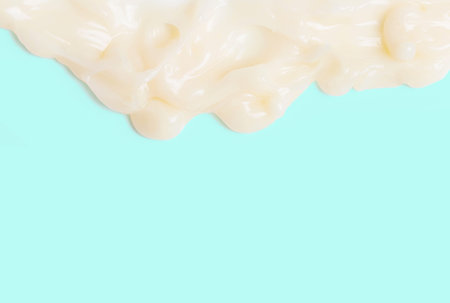 Moisturizing shampoo dripping down on blue background close-up.